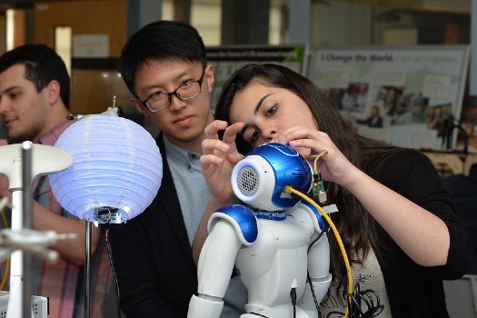 Students working on robot in electronics lab.
